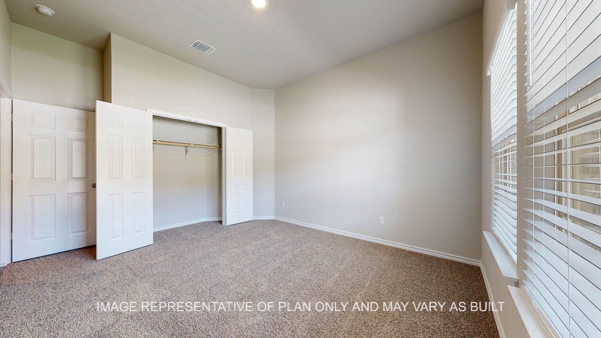 Elmwood secondary bedroom with carpet flooring and closet.