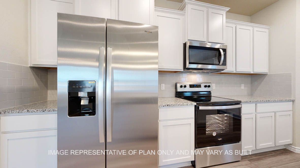 Elmwood kitchen with white cabinets and stainless appliances.