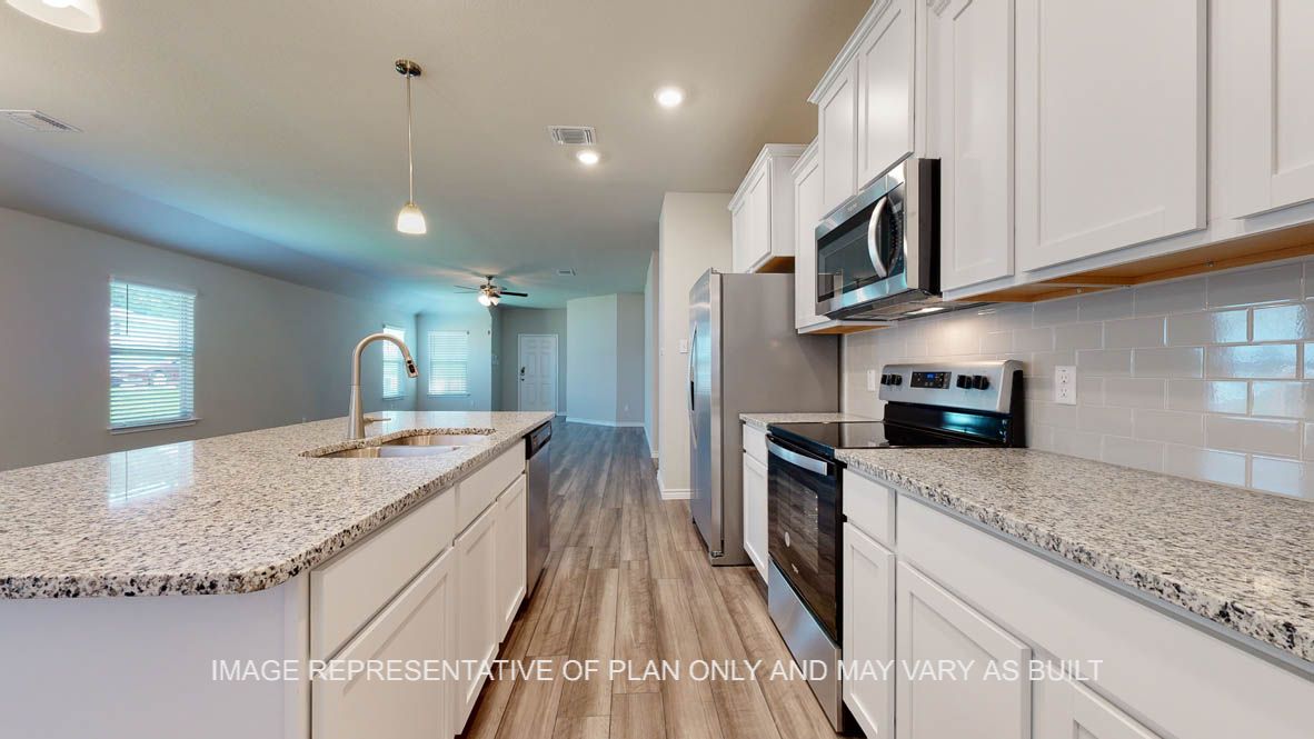 Elmwood kitchen with vinyl plank flooring and subway tile backsplash.