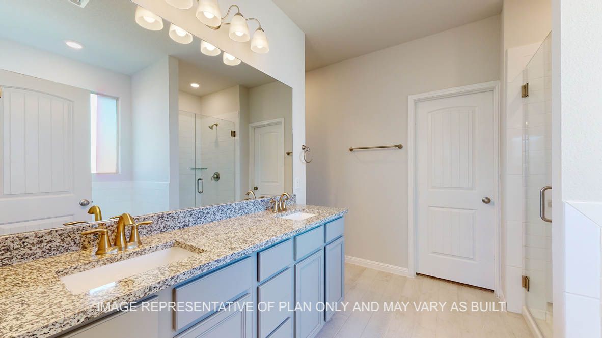 Parker primary bath with light griege cabinets and granite countertops and dual vanities.