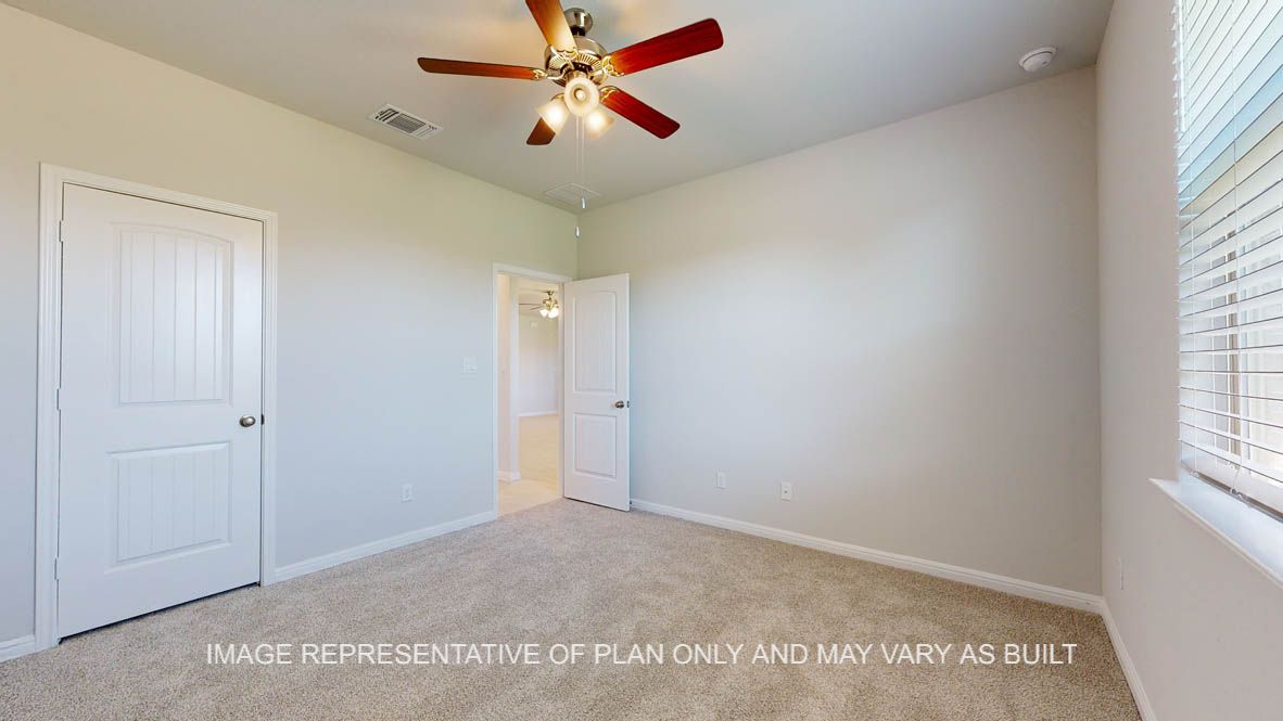 Parker secondary bedroom with carpet flooring and windows.
