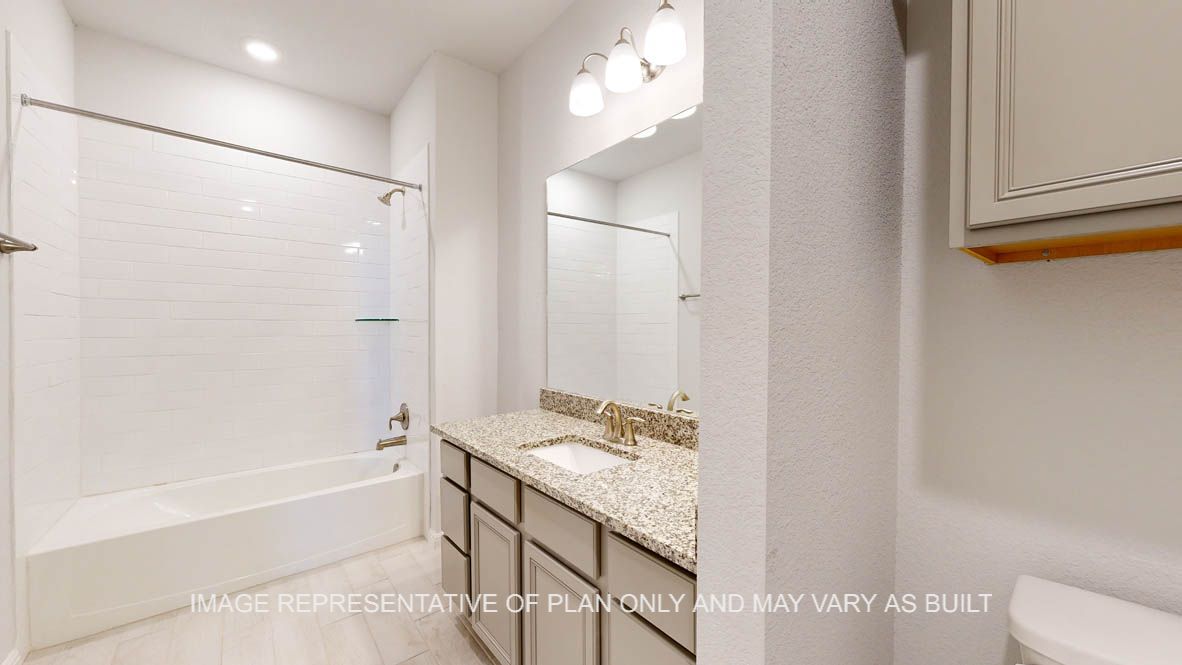 Parker secondary bath with granite countertops and wood look tile flooring.