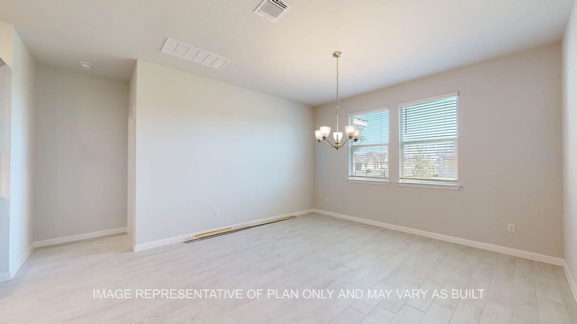 Parker dining with ample windows for natural lighting and wood look tile flooring.