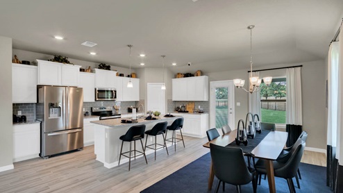 Delaware Springs model home dining room with table and view of the kitchen.