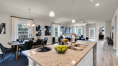Delaware Springs model home kitchen sink with view of dining and living room.