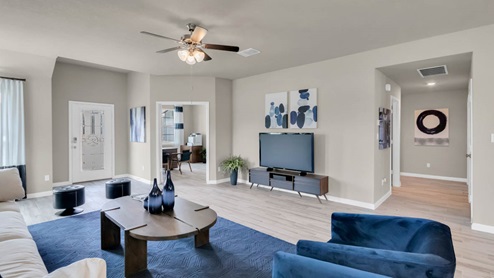 Delaware Springs model home living room with view of secondary bedroom and hallway.
