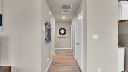 Delaware Springs model home hallway entry with view of secondary bedroom.