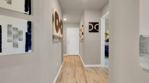 Delaware Springs model home hallway entry with view of secondary bedroom.