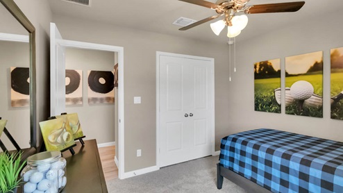 Delaware Springs model home secondary bedroom with a twin bed and carpet flooring.