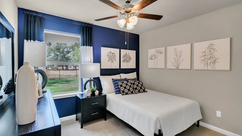 Delaware Springs model home secondary bedroom with a twin bed and carpet flooring.