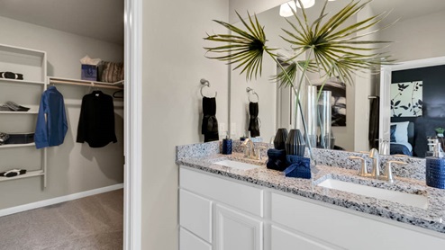 Delaware Springs model home primary bathroom with double vanity sink and mirrors.