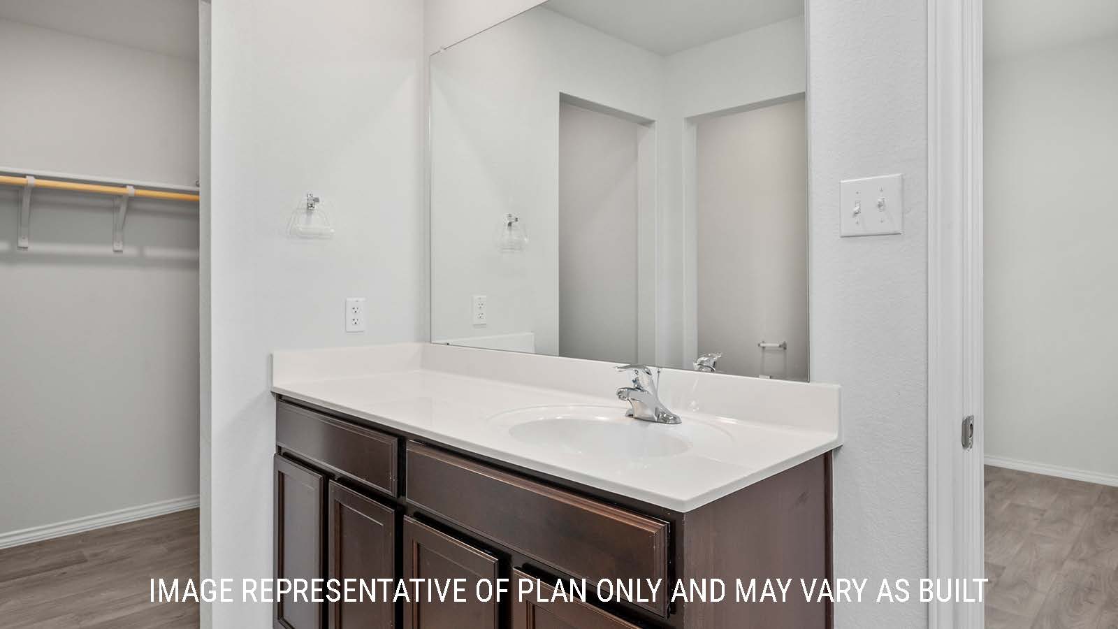 Ashburn primary bathroom with single vanity sink and view of primary closet.