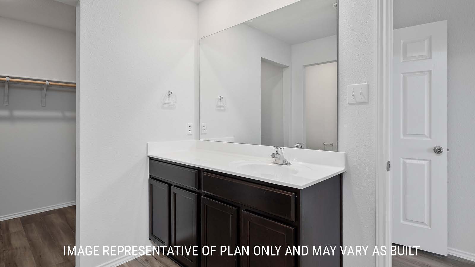 Bellvue primary bathroom with single vanity and view of primary closet.