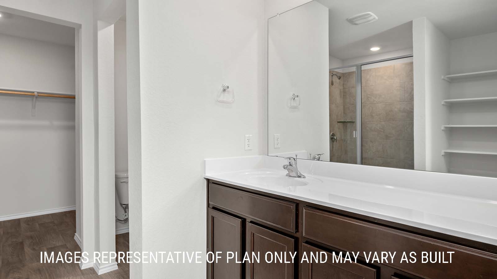 Fargo primary bathroom with single vanity sink and view of primary closet.