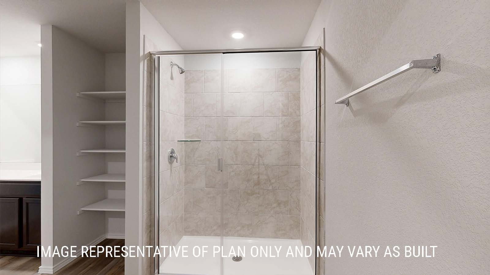 Seabrook primary bathroom with view of walk-in shower and shelving for storage.