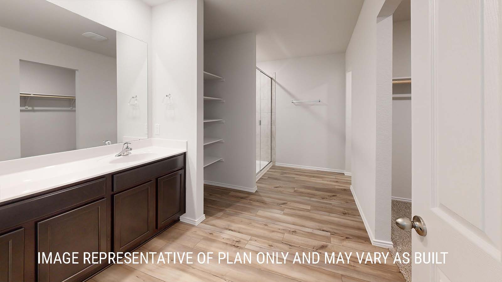 Seabrook primary bathroom with single vanity sink and view of the primary walk-in closet.