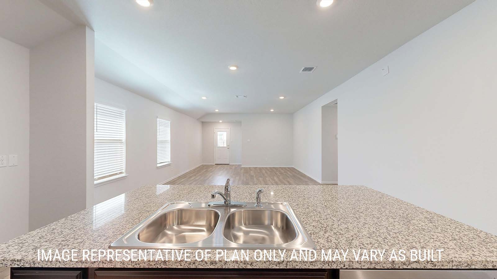 Seabrook kitchen with center kitchen island with granite countertops and view of open concept dining room and living room.