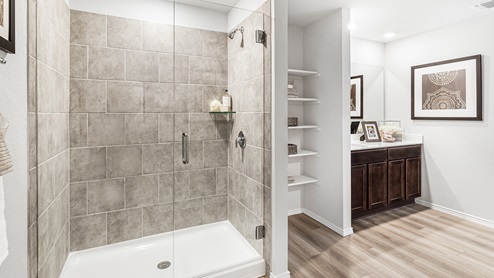 Mitchell Farm model home primary bathroom with walk-in shower and storage shelving.