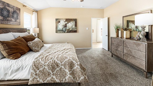 Mitchell Farm model home primary bedroom with a king bed and carpet flooring.