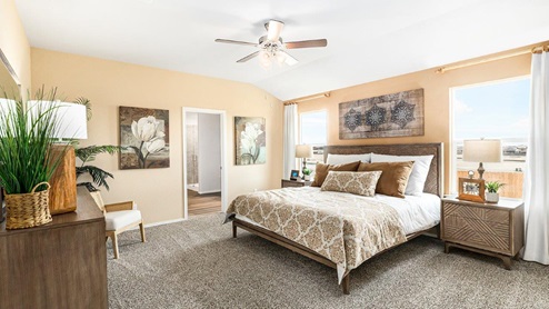 Mitchell Farm model home primary bedroom with a king bed and view of the primary bathroom.