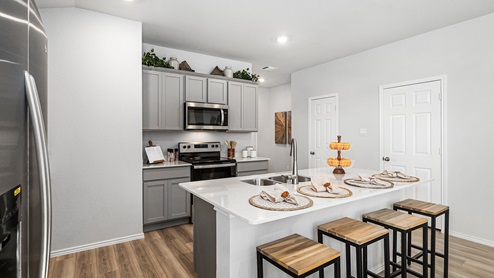 Mitchell Farm model home kitchen with gray cabinets and quartz countertops.
