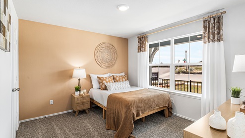 Mitchell Farm model home secondary bedroom with a full-size bed and carpet flooring.