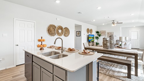 Mitchell Farm model home kitchen with open concept of the dining and living room.