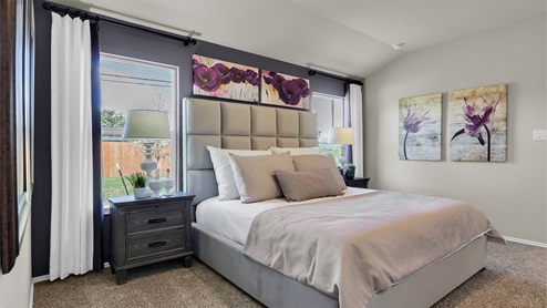 Reynolds Crossing model home primary bedroom furnished with king-sized bed.