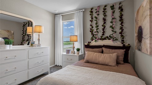 Reynolds Crossing model home secondary bedroom furnished.