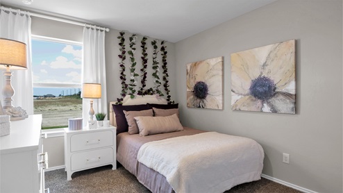 Reynolds Crossing model home secondary bedroom furnished.