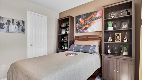 Reynolds Crossing model home secondary bedroom furnished.
