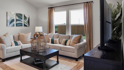 Victory Ranch model home living room furniture with window and view to backyard.