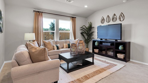 Victory Ranch model home living room furniture with window and view to backyard.