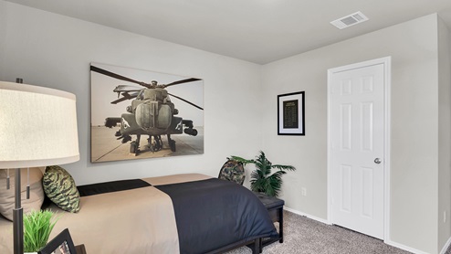 Victory Ranch secondary bedroom with carpet flooring and furniture and design accents.
