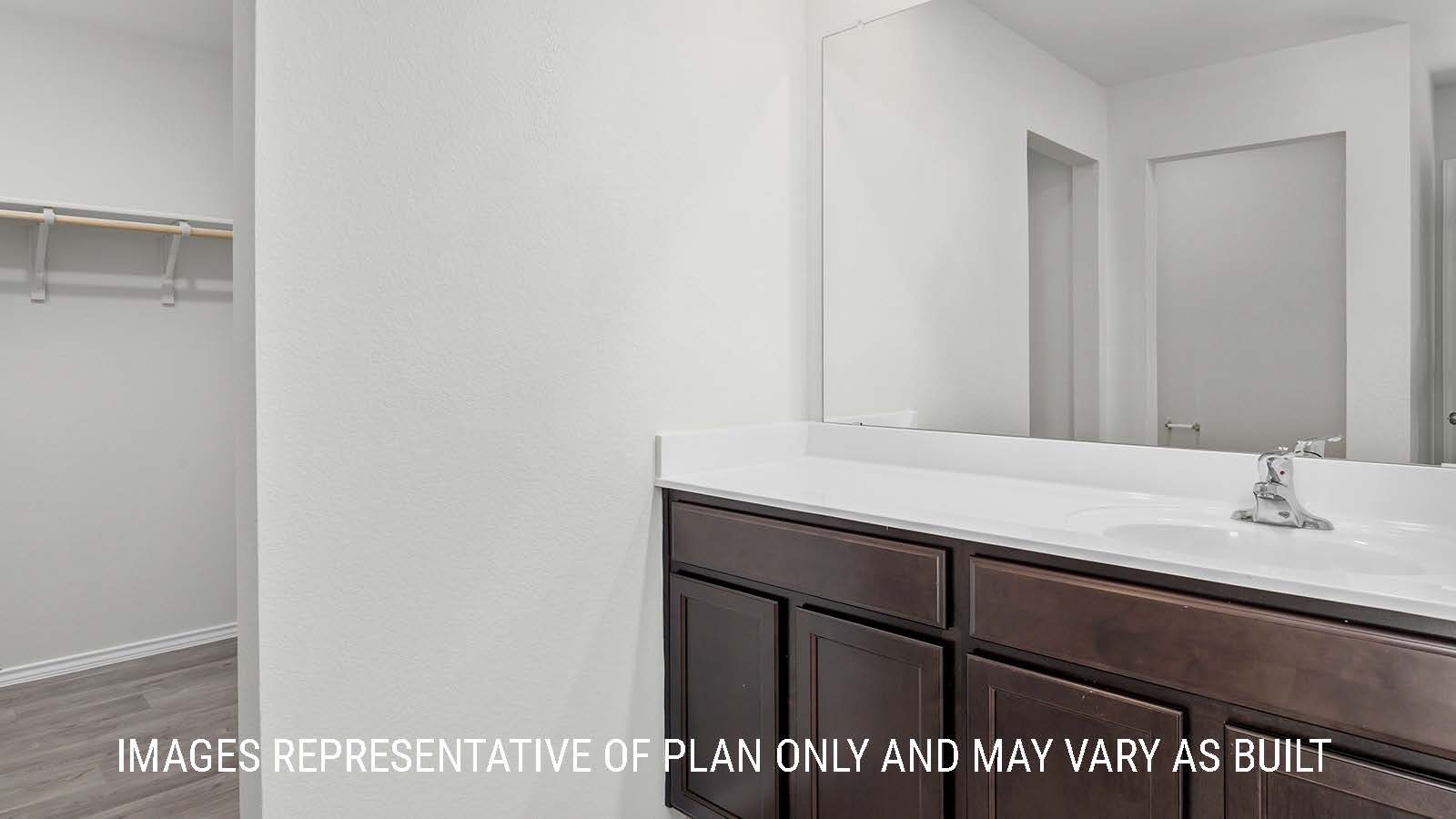 Texas Cali primary bathroom with single vanity sink and view of primary closet.