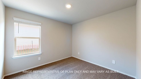 Fargo secondary bedroom with carpet flooring and window.