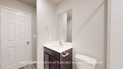 Fargo secondary bath with dark cabinets and white countertops.