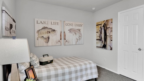 West Canyon Trails Model Home Secondary bedroom decorated with furniture, carpet flooring and light painted walls.