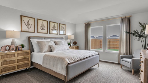West Canyon Trails Model Home primary bedroom decorated with neutral furniture and windows