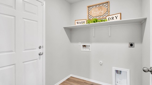 West Canyon Trails Model Home utility room with storage shelving and washer and dryer connections.