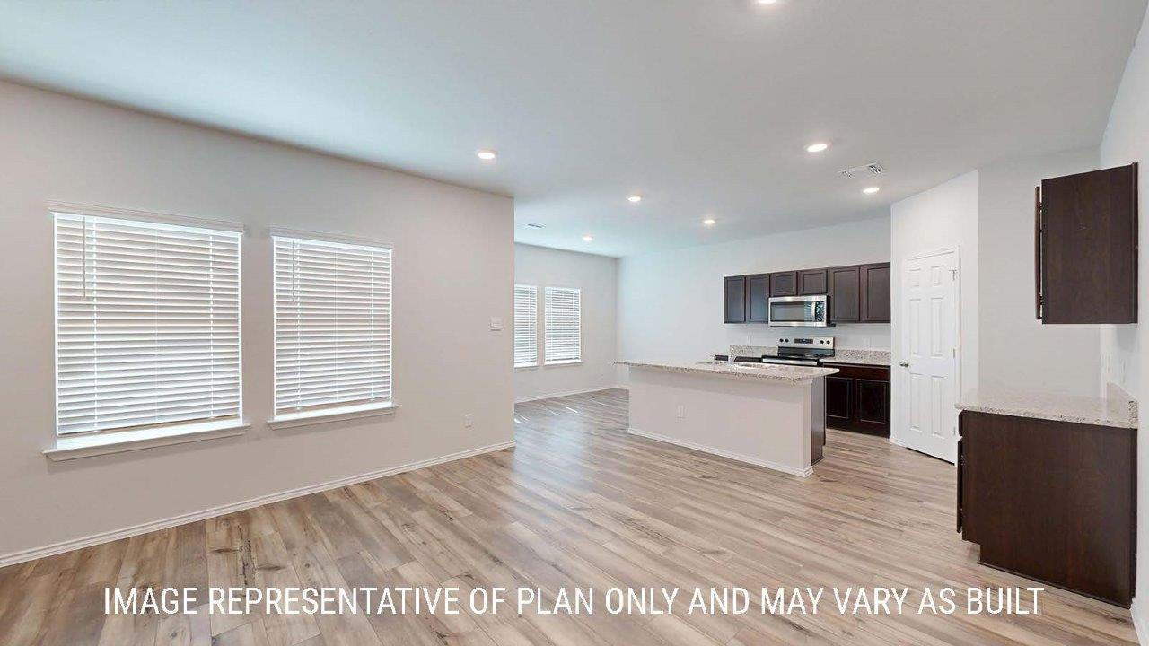 Emma living room with vinyl plank flooring and view of kitchen and dining room.