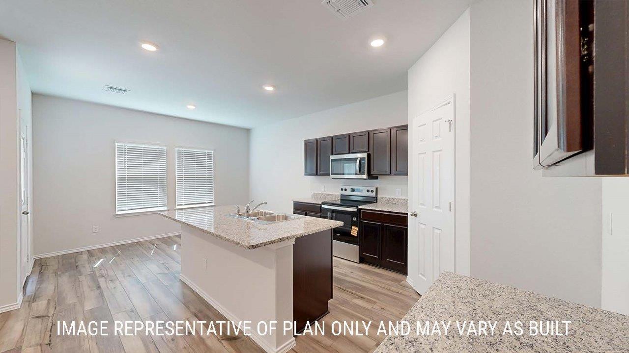Emma kitchen with center kitchen island with granite countertops and view of dining room.