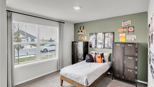 Eastern Wells Model Home secondary bedroom with twin bed and sage green accent wall.