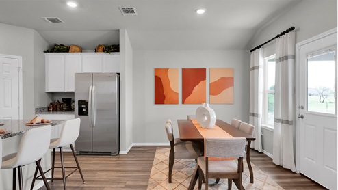Eastern Wells Model Home dining room with view into open kitchen layout.