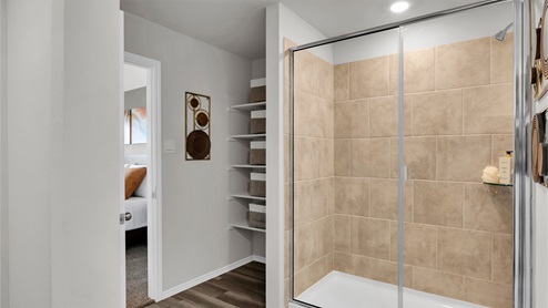 Eastern Wells Model Home primary bathroom with walk-in shower and ceramic tile surround.