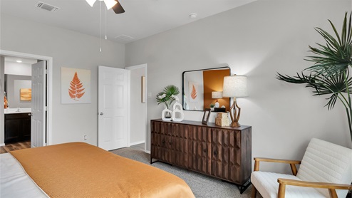 Eastern Wells Model Home primary bedroom with view into attached bathroom.