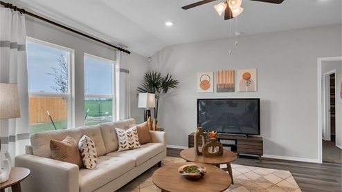 Eastern Wells Model Home living room with furniture and orange decorative accents.