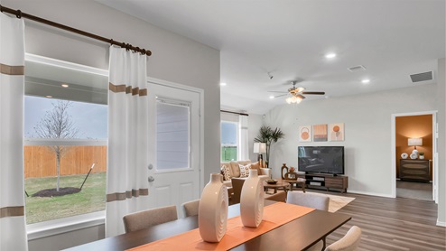 Eastern Wells Model Home dining room with view into furnished living room.