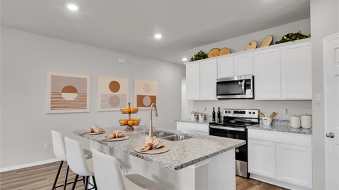 Eastern Wells Model Home kitchen with granite countertops and stainless appliances.