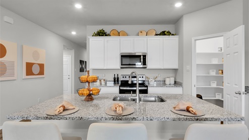 Eastern Wells Model Home kitchen with center island and bar stools for additional seating.